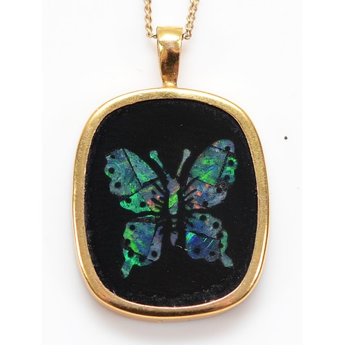 58 - A 9ct gold black onyx pendant with an opal butterfly inlay, on a chain, 1.8g