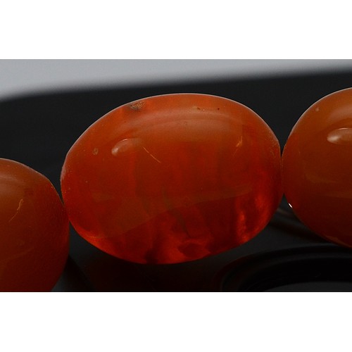 50 - An amber beaded necklace, largest bead 14mm, 41cm, 23g