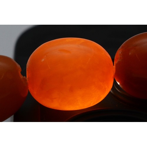 50 - An amber beaded necklace, largest bead 14mm, 41cm, 23g