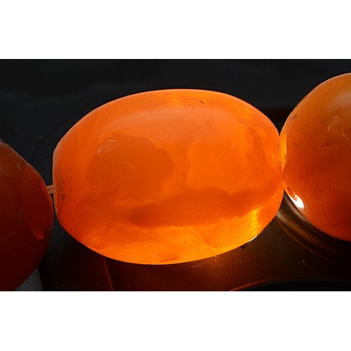 50 - An amber beaded necklace, largest bead 14mm, 41cm, 23g