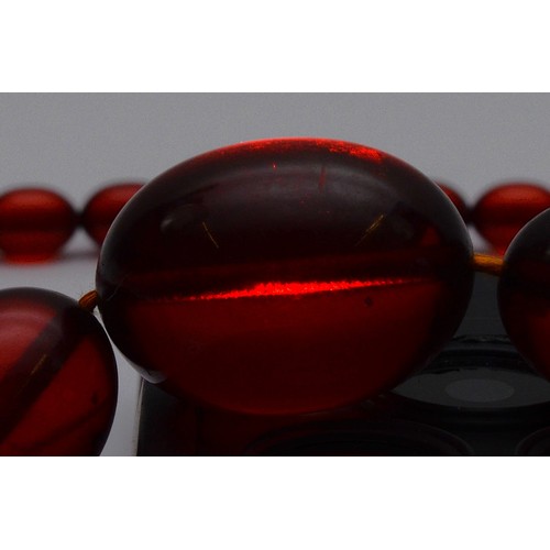 51 - A cherry Bakelite beaded necklace, largest bead 25mm, screw closure, 90cm, 52g