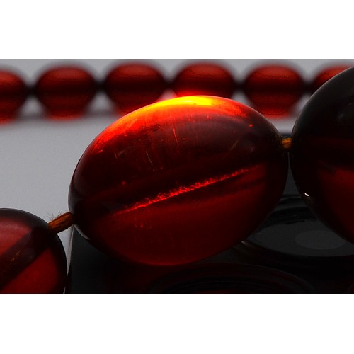 51 - A cherry Bakelite beaded necklace, largest bead 25mm, screw closure, 90cm, 52g