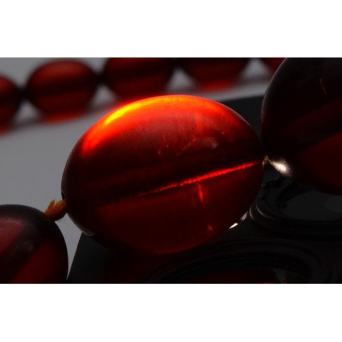 51 - A cherry Bakelite beaded necklace, largest bead 25mm, screw closure, 90cm, 52g
