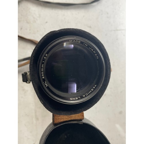 23 - A box of camera lens to include a Yashica 1:5.6 300mm lens, a Sigma 1:4.5 70-210mm lens, a CanonEF 5... 