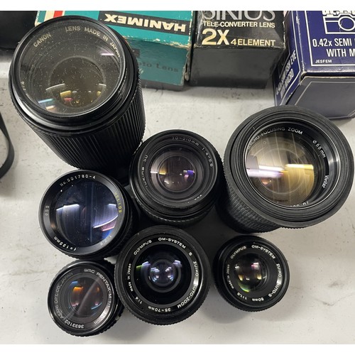 28 - A box of camera lens to include an Olympus 50mm 1:1.8 lens, an Olympus 35-70mm 1:4 lens, a Tokina 70... 