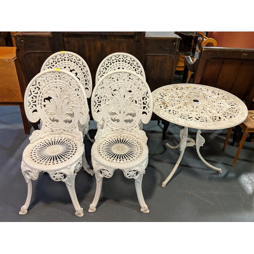 253 - White cast iron patio table and four chairs