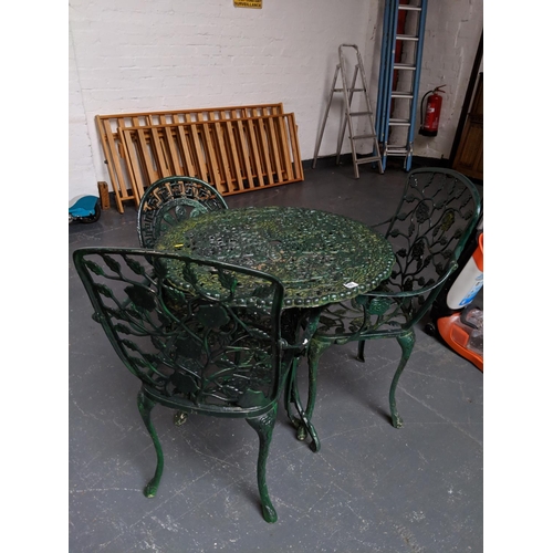 699 - Cast iron table and 3 chairs