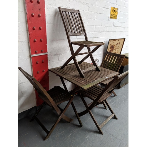 753 - A wooden garden table and four folding chairs