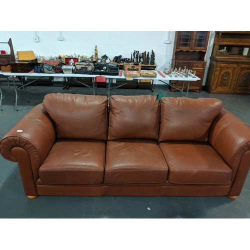 239 - A tan leather three seater settee