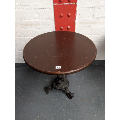 514 - A circular pub table with a cast iron pedestal base