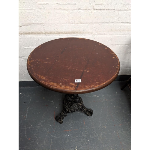 516 - A circular pub table with a cast iron pedestal base