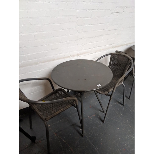 525 - A circular metal patio table and two chairs