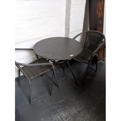 526 - A circular metal patio table and two chairs