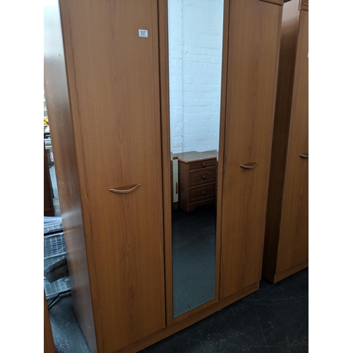537 - A double door wardrobe with mirrored centre panel