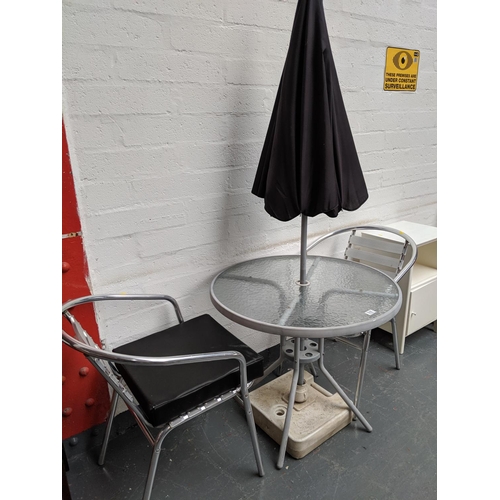 510 - A patio table, two aluminium patio chairs and umbrella