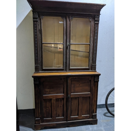 229 - An antique pine bookcase above a two door cupboard