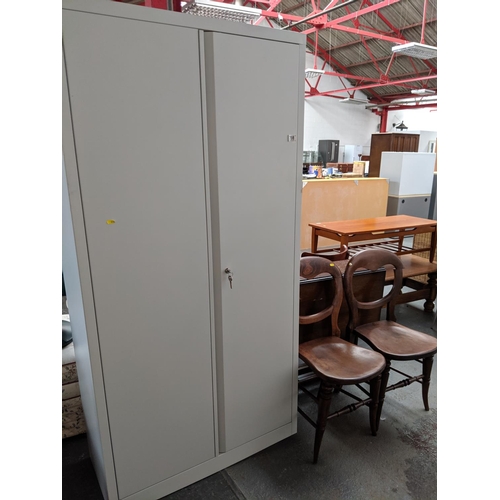 708 - A metal cabinet, two hall chairs and a drop leaf table