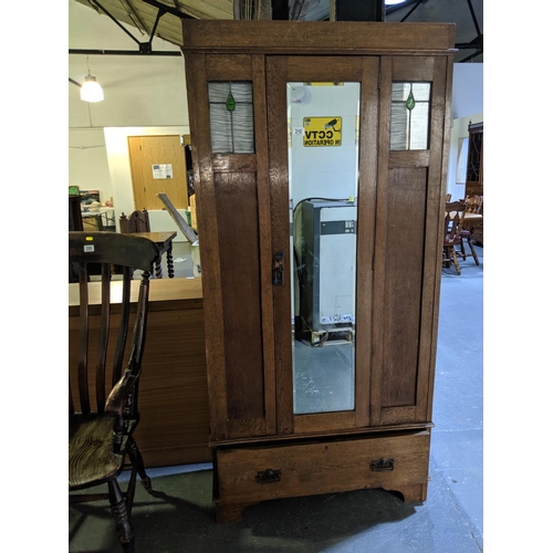 210 - An oak, arts and crafts single door wardrobe with drawer