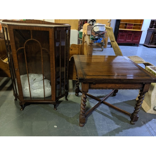 215 - An oak draw leaf dining table with barley twist legs and a display cabinet