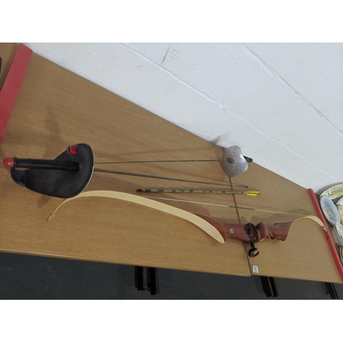 101 - A pair of fencing foils and an archery longbow (english)