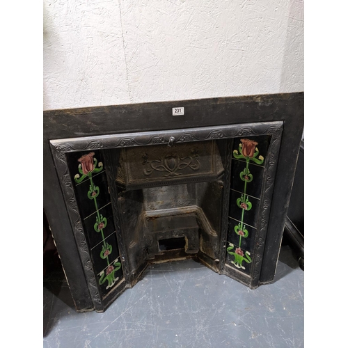 231 - A cast iron and tiled fireplace