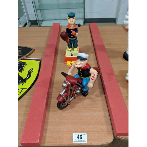 46 - Two cast iron Popeye figures, one boxing and one on a motorbike