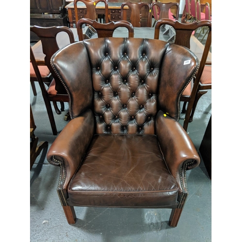 226 - A brown leather wingback, chesterfield chair