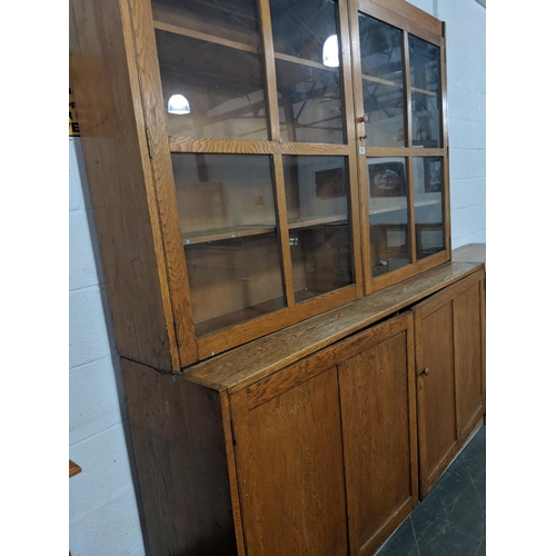 205 - An oak school cabinet with glazed top section