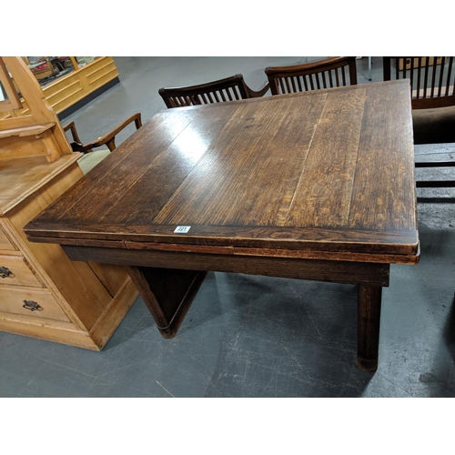 221 - An oak draw leaf extending dining table and four chairs