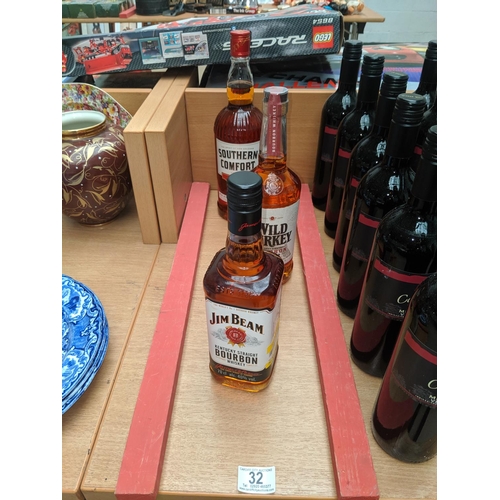 32 - A bottle of Southern Comfort, Wild Turkey bourbon whiskey and a bottle of Jim Beam