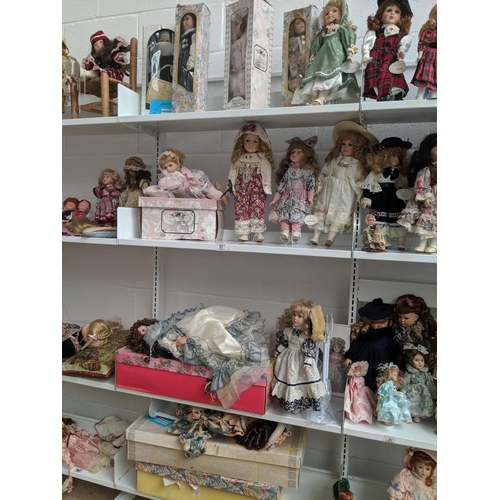 51 - 4 shelves of porcelain dolls including Leonardo collection etc.