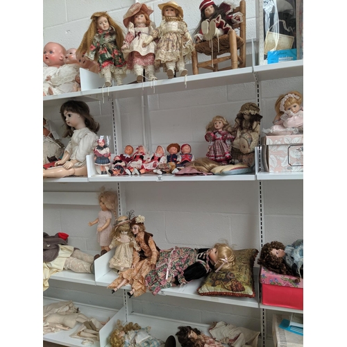52 - 4 shelves of collectors dolls including dolls from around the world etc.