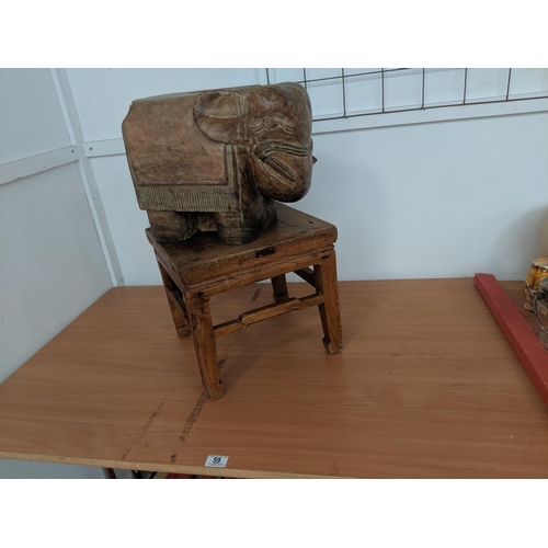 59 - A wooden carved elephant on wooden stool