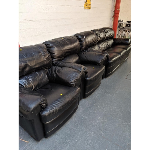 710 - A black leather three seater sofa and two matching armchairs