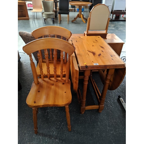 726 - A pine drop leaf dining table and two chairs