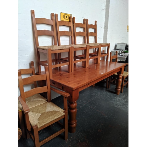 522 - A large pine kitchen table with drawers and 8 chairs
