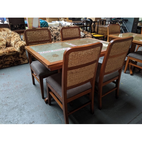 756 - A teak glass topped dining table with four rattan backed chairs
