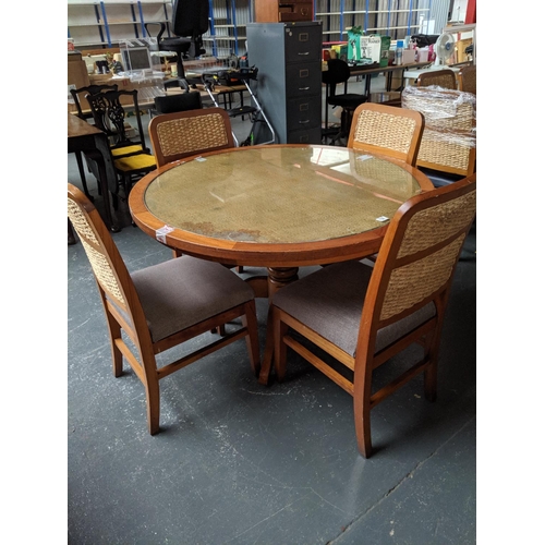 758 - A circular teak glass topped dining/restaurant table with four rattan backed chairs