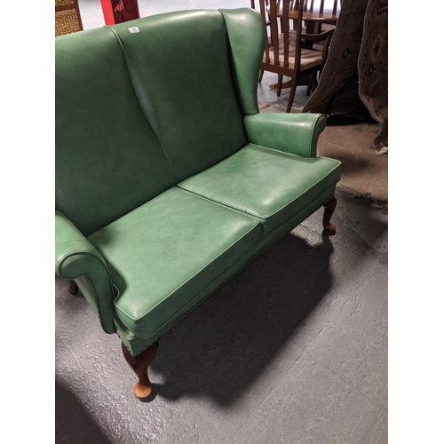 745 - A green leather parker knoll two seater sofa