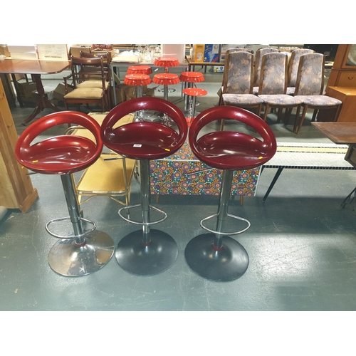 556 - Three chrome and red bar stools