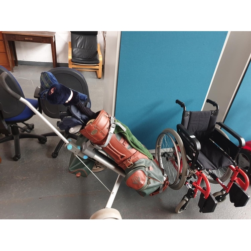 344 - A golf carrier with golf bag and clubs and a child's wheelchair