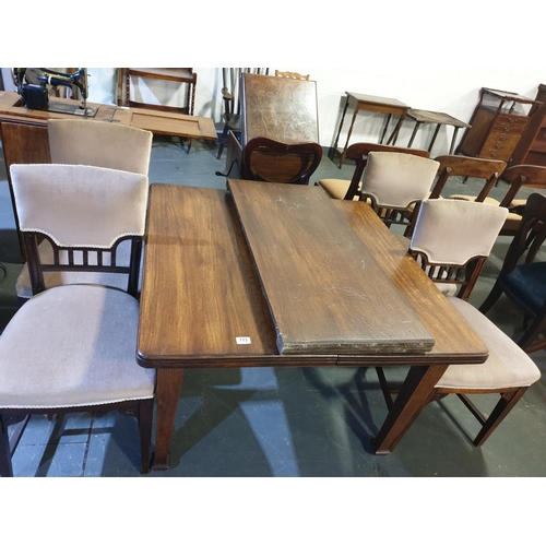 113 - An extending oak dining table with extra leaf and crank, and four chairs