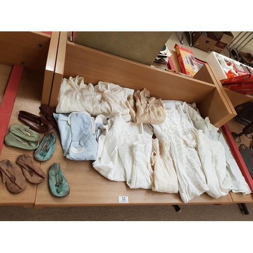 33 - A collection of antique baby shoes, christening gowns and clothing