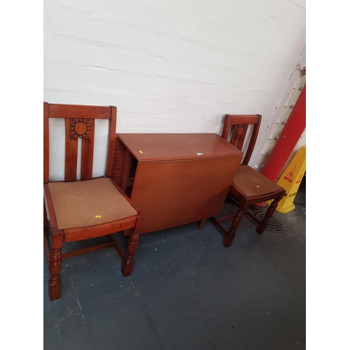 518 - A drop leaf dining table and two chairs.