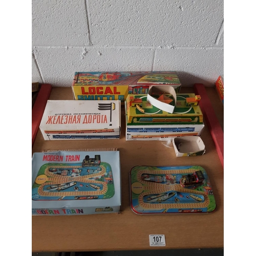 107 - A boxed 'Lovely Toys' wind up tin local shuttle return train, two boxed Russian wind up tin plate tr... 