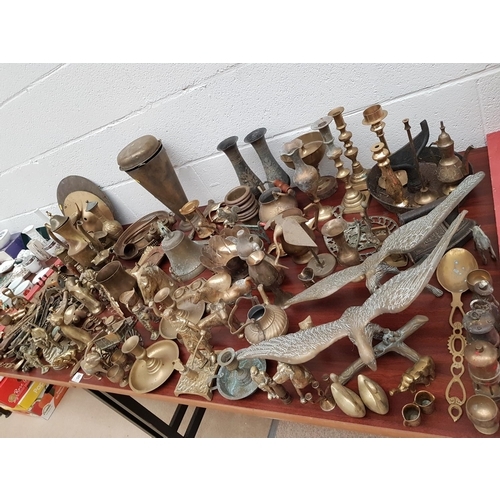 58 - A large quantity of brass ware including bell, candlesticks, birds of prey etc