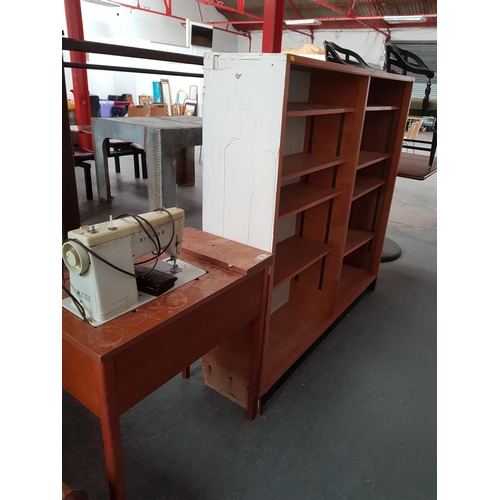 539 - A double wooden bookcase with adjustable shelving and singer sewing machine with cabinet, stools cha... 