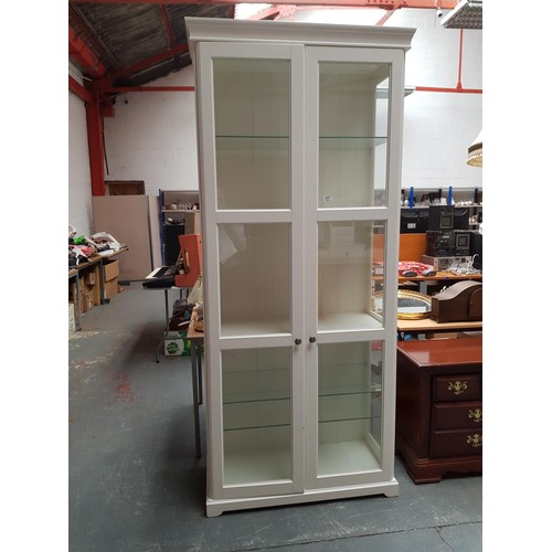 577 - A tall white glazed display cabinet