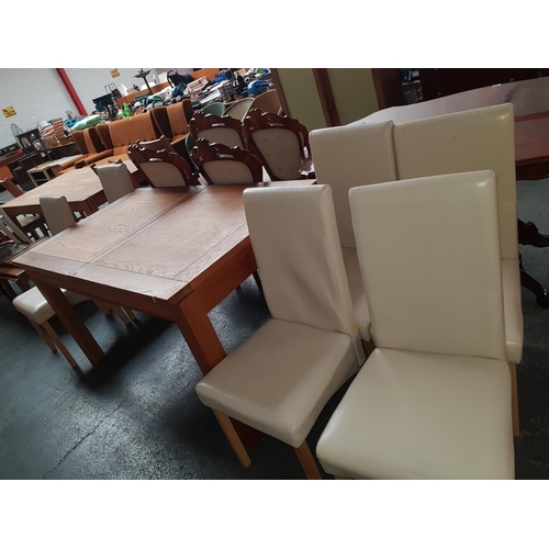 348 - A solid oak extending dining table and 4 cream leatherette chairs