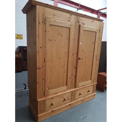 331 - A large pine wardrobe with 2 drawers to the bottom